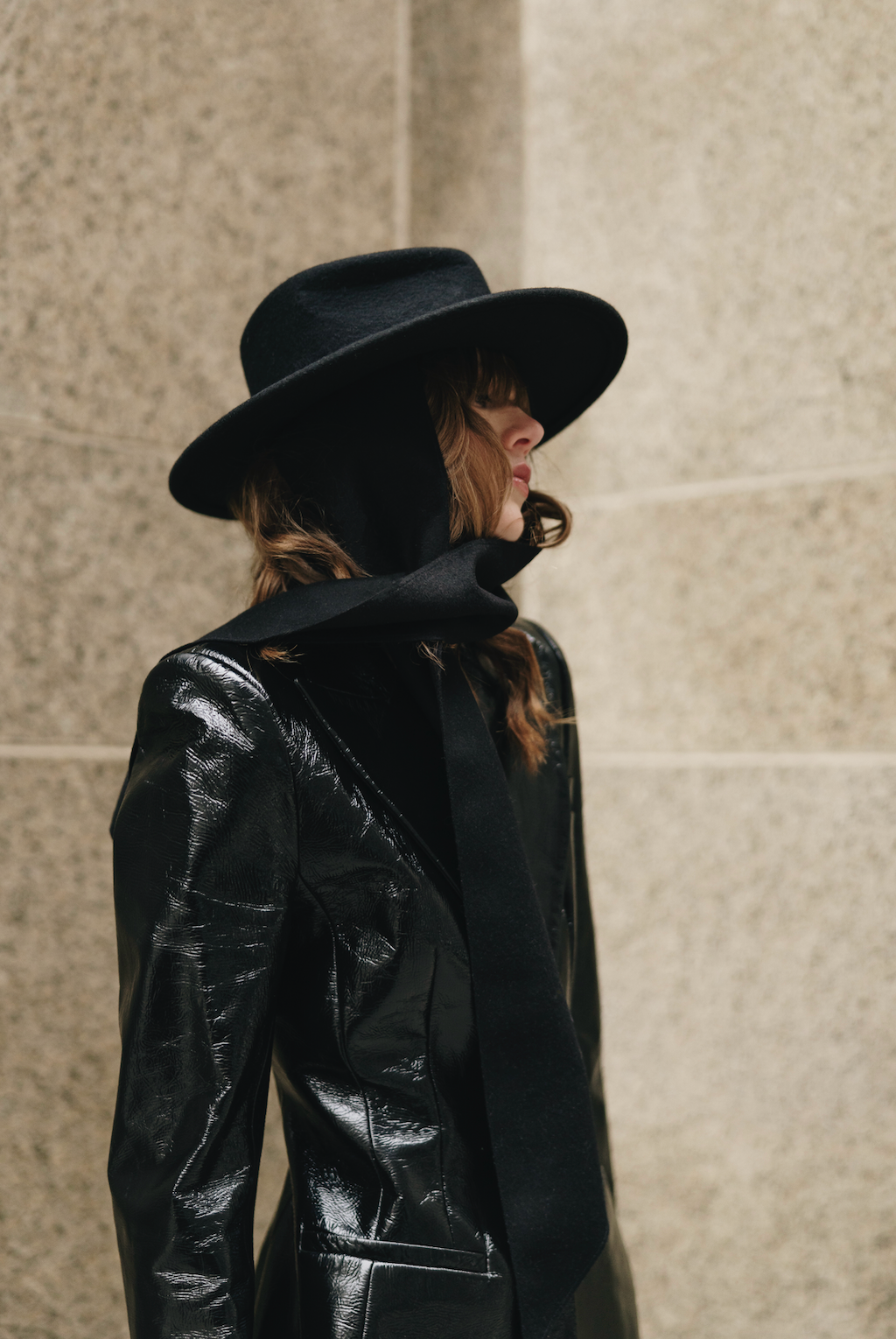Black hat with a long black bow tie on a model