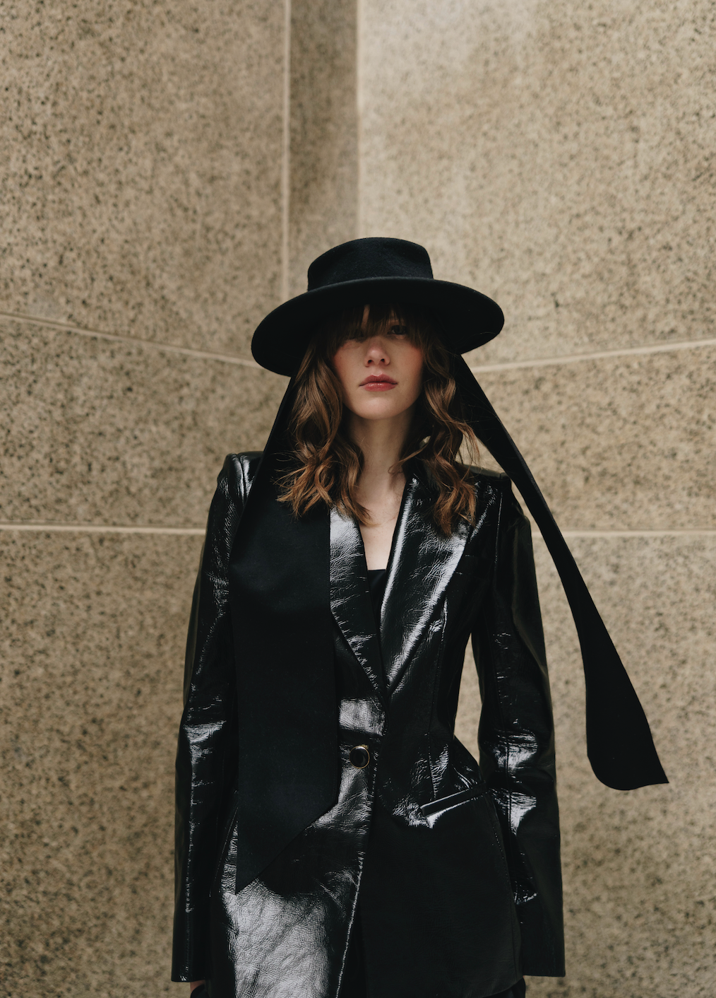 Black hat with a long black bow tie on a model