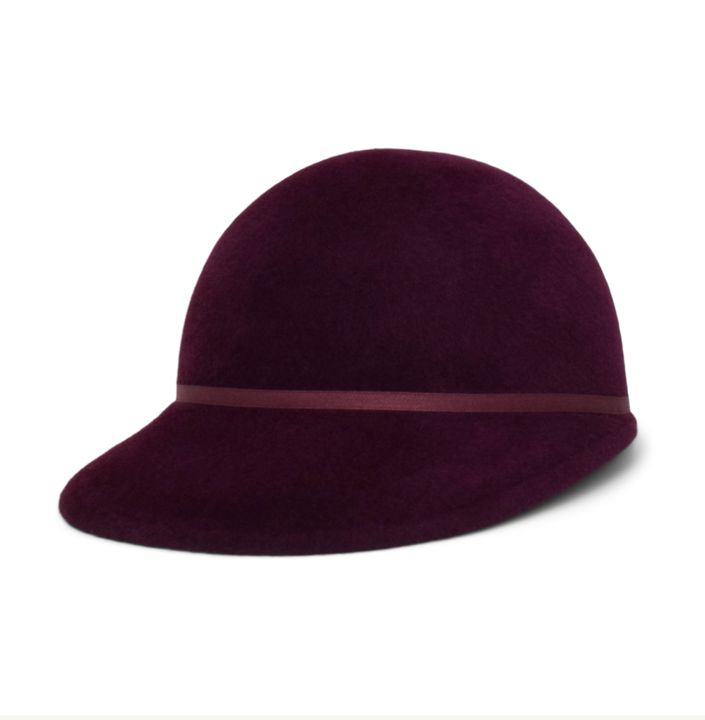 Purple felt hat with a band on a white background