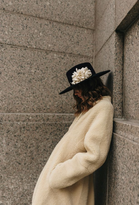 Black hat with white flower on model