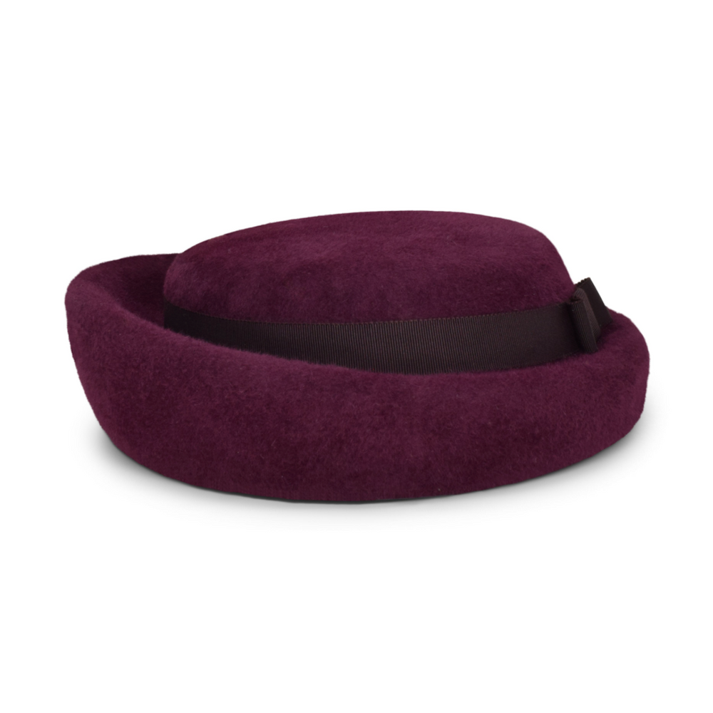 Purple travel pillow with a black strap on a white background