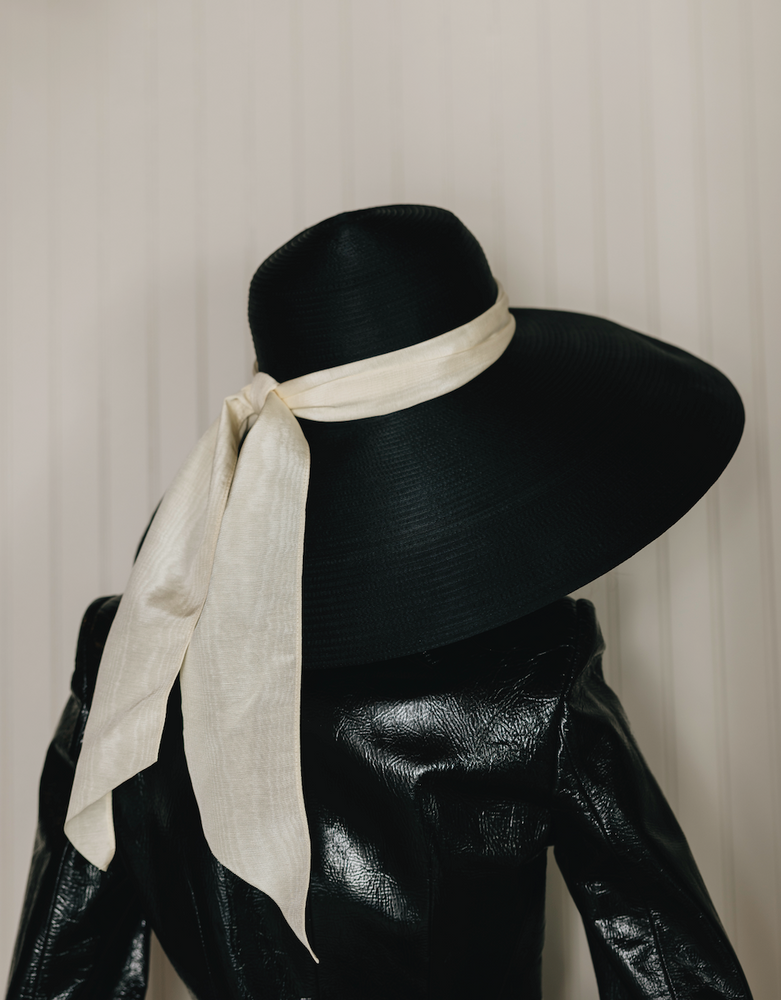 Black, dramatic, statement hat, white ribbon on model